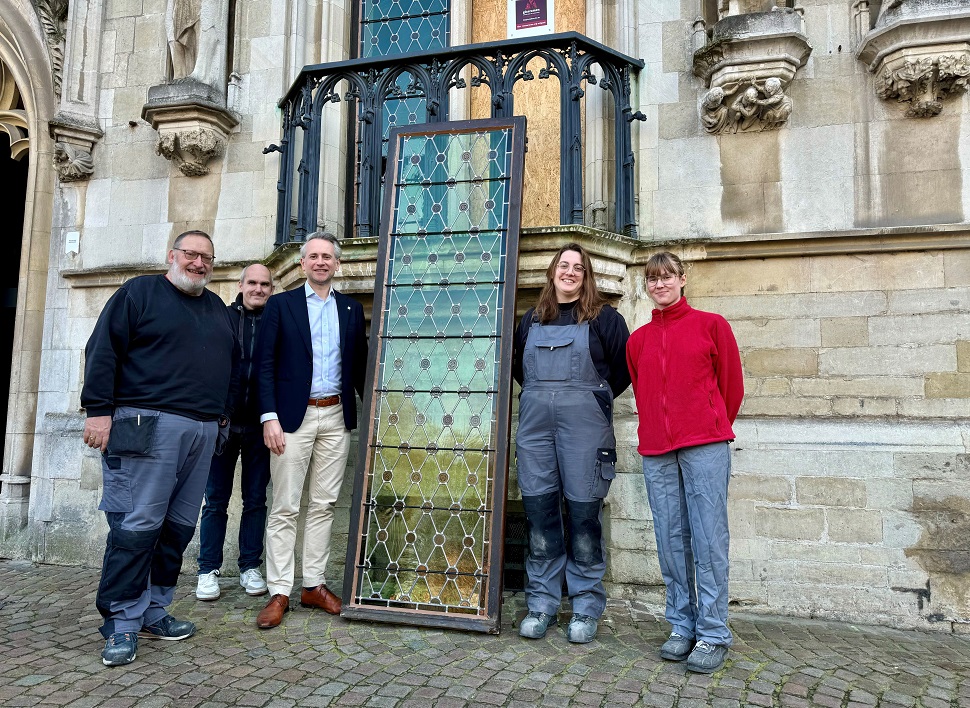 Plaatsing van gerestaureerde glaspanelen aan balkon Brugse Stadhuis